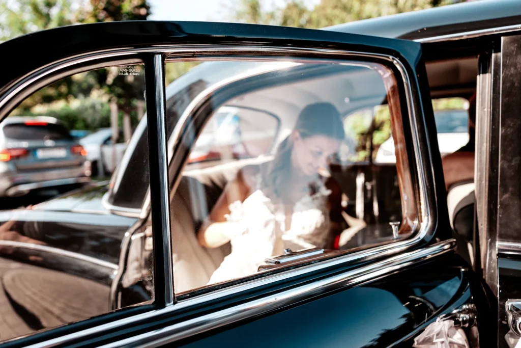 Bei der standesamtlichen Hochzeit von Justine & Maurice in Essen-Kettwig steigt Justine in einen Oldtimer ein.